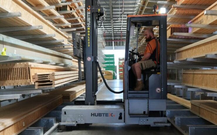 Sideloader forklifts working in narrow aisle
